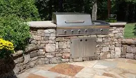 Stone outdoor kitchen with a built-in stainless grill